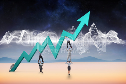 Composite image of business team holding up arrow