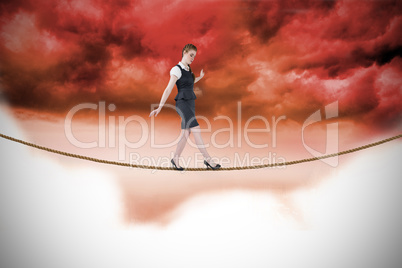 Composite image of businesswoman doing a balancing act