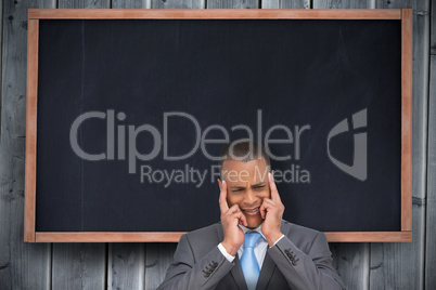 Composite image of stressed businessman putting his fingers on h