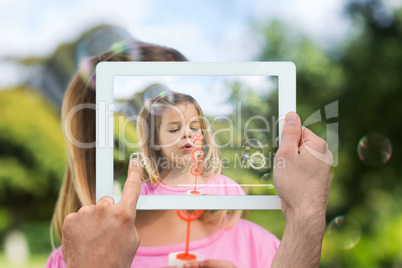 Composite image of hand holding tablet pc