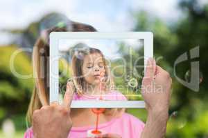 Composite image of hand holding tablet pc