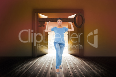 Composite image of annoyed brunette carrying large key