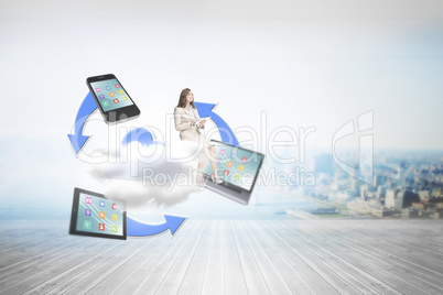 Composite image of businesswoman holding tablet and looking up