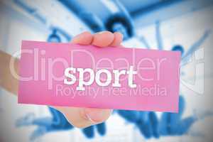 Woman holding pink card saying sport