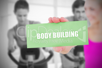 Fit blonde holding card saying body building