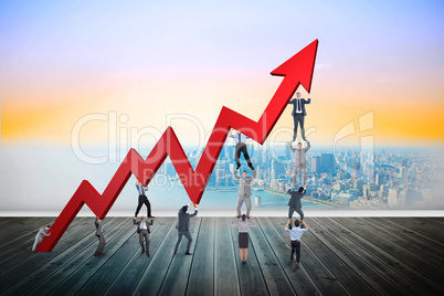 Composite image of business team holding up arrow