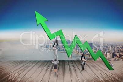 Composite image of business team holding up arrow