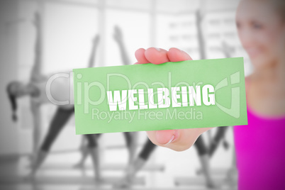 Fit blonde holding card saying wellbeing