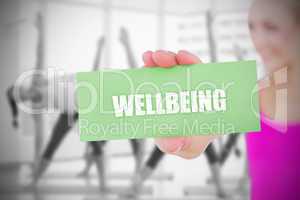 Fit blonde holding card saying wellbeing