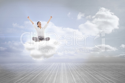 Composite image of cheering businesswoman sitting cross legged