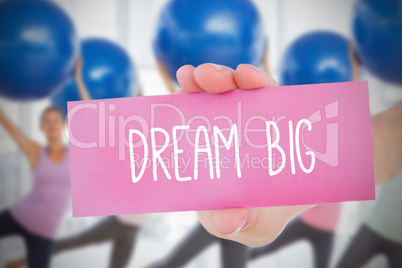 Woman holding card saying dream big