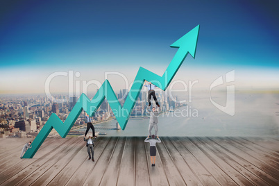 Composite image of business team holding up arrow