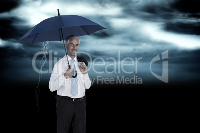 Composite image of happy businessman holding umbrella