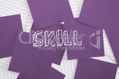Skill against purple paper strewn over notepad