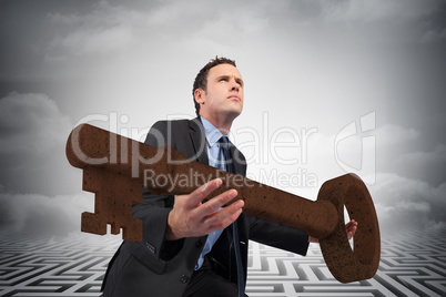 Composite image of businessman carrying large key