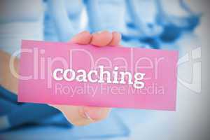Woman holding pink card saying coaching