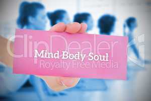 Woman holding pink card saying mind body soul