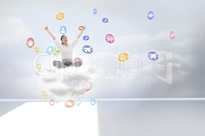 Composite image of cheering businesswoman sitting cross legged