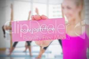 Fit blonde holding card saying competition