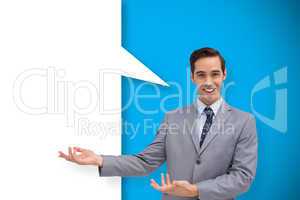 Composite image of young businessman presenting something with s