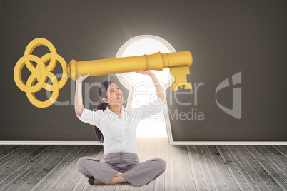 Composite image of businesswoman sitting cross legged carrying l