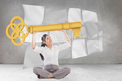 Composite image of businesswoman sitting cross legged carrying l