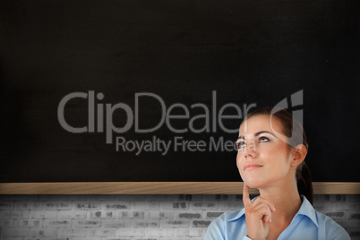 Composite image of thinking businesswoman looking upwards