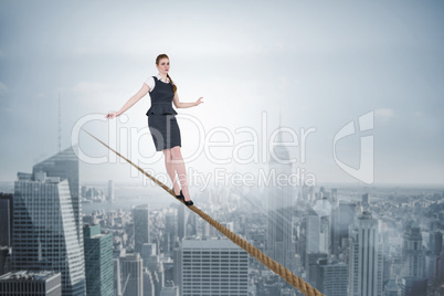 Composite image of businesswoman doing a balancing act