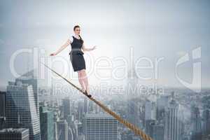 Composite image of businesswoman doing a balancing act