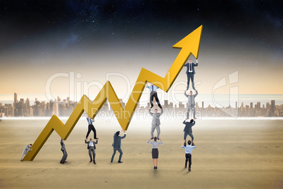 Composite image of business team holding up arrow Composite image of business team holding up arrow