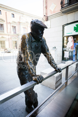 Conteporan street sculpture of a person on Calle Almudena in Mad