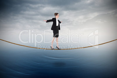 Composite image of businesswoman performing a balancing act