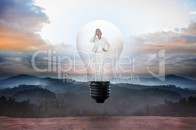 Composite image of thinking businesswoman in light bulb