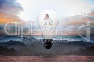 Composite image of thinking businesswoman in light bulb