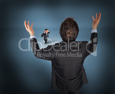 Composite image of gesturing businessman with tiny businessman