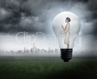 Composite image of thinking businesswoman in light bulb