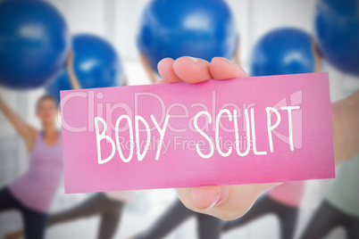 Woman holding pink card saying body sculpt