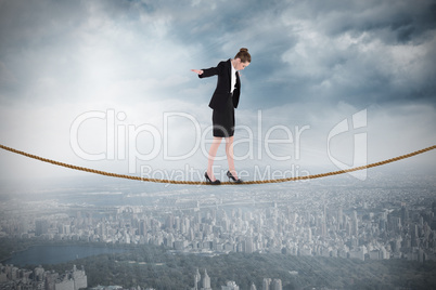 Composite image of businesswoman performing a balancing act