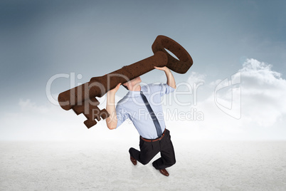 Composite image of businessman carrying large key