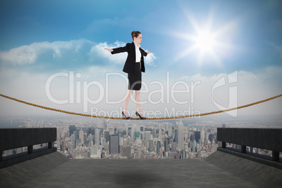 Composite image of businesswoman performing a balancing act