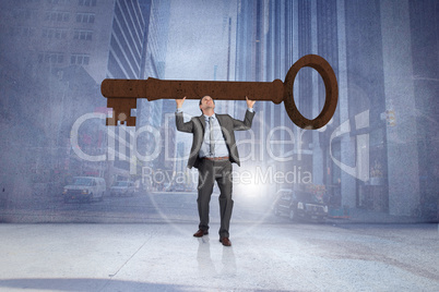 Composite image of businessman carrying large key