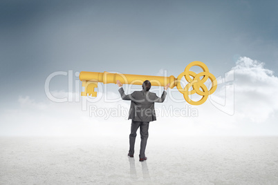 Composite image of businessman carrying large key