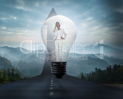 Composite image of thinking businesswoman in light bulb