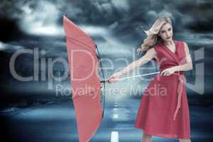 Composite image of elegant blonde holding umbrella