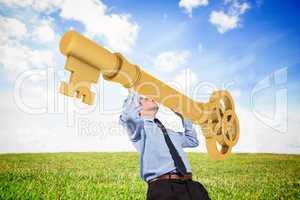 Composite image of businessman carrying large key