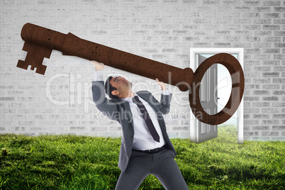Composite image of unsmiling businessman carrying large key