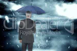 Composite image of businessman holding umbrella