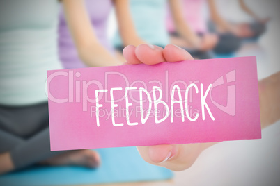 Woman holding pink card saying feedback