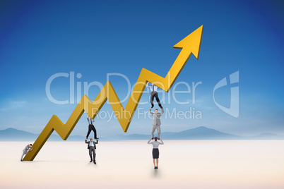 Composite image of business team holding up arrow