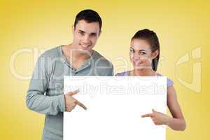 Composite image of attractive young couple showing card